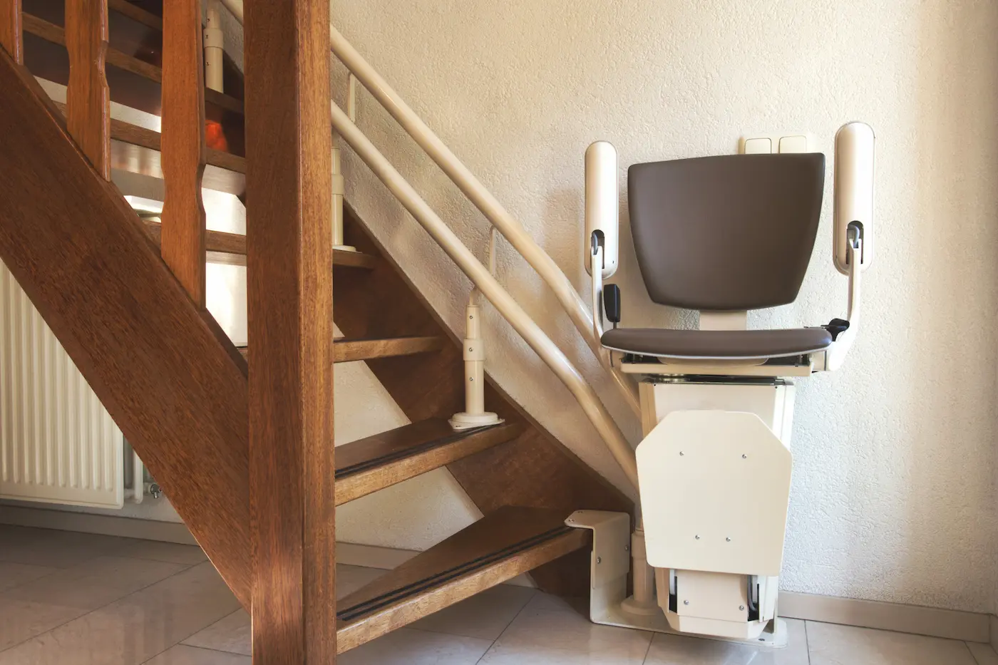 Escalera de madera de una vivienda de Pozuelo de Alarcón con una silla salvaescaleras instalada